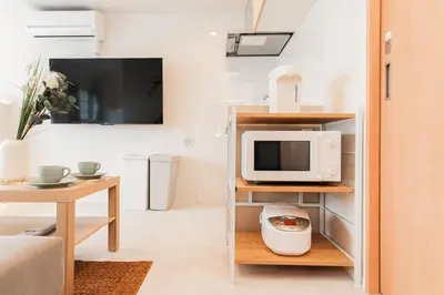 a living room with a microwave on a shelf at Shinjuku SAIEI Hotel 401 in Tokyo