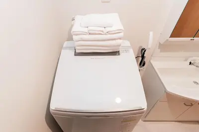 a bathroom with a white toilet with towels on it at Shinjuku SAIEI Hotel 401 in Tokyo