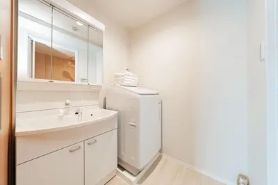 a white bathroom with a sink and a refrigerator at Shinjuku SAIEI Hotel 402 in Tokyo