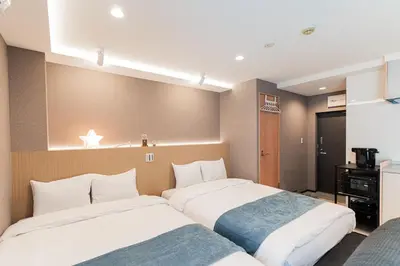 two beds sitting next to each other in a room at Shinjuku SAIEI Hotel 402 in Tokyo
