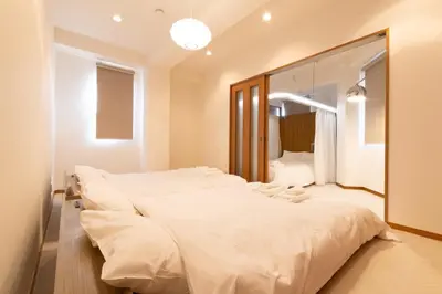 a bedroom with a large white bed and a mirror at Swan Lake Inn Shinjuku - Vacation STAY 19482 in Tokyo