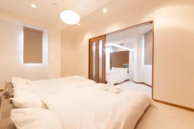 a bedroom with two beds and a large mirror at Swan Lake Inn Shinjuku - Vacation STAY 19482 in Tokyo