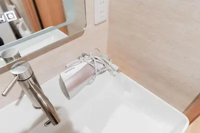 a white bathroom sink with a faucet and a mirror at Shinjuku SAIEI Hotel 501 in Tokyo