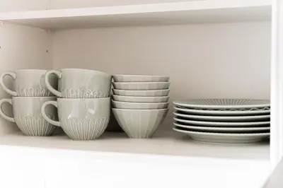 a group of cups and plates on a shelf at Shinjuku SAIEI Hotel 501 in Tokyo
