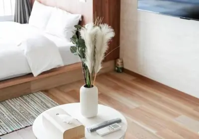 a white vase with feathers on a table in a bedroom at Shinjuku SAIEI Hotel 501 in Tokyo