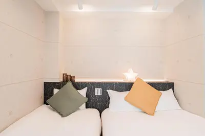 a bedroom with two beds and two pillows at Shinjuku SAIEI Hotel 502 in Tokyo
