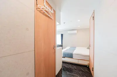a room with a bed and a door to a bedroom at Shinjuku SAIEI Hotel 502 in Tokyo
