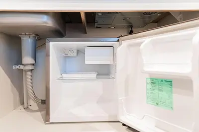 an open refrigerator in a kitchen with a sink at Shinjuku SAIEI Hotel 502 in Tokyo