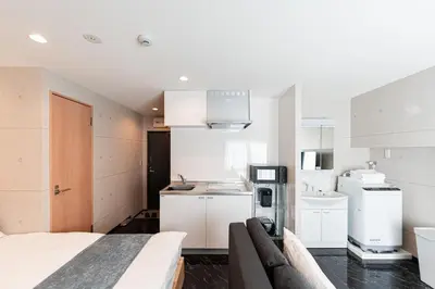 a kitchen with white cabinets and a sink in a room at Shinjuku SAIEI Hotel 502 in Tokyo
