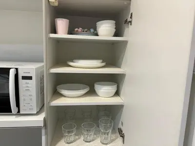 a pantry with dishes and cups and a microwave at Yoyogi Premier 4BR House in Tokyo