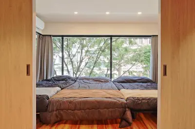 a bed in a room with a large window at Steps from Shibuya Crossing B in Tokyo