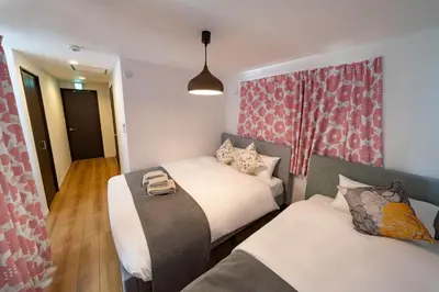 two beds in a small room with avertisement for at \u845b\u98fe\u9ad8\u7802\u6238\u5efa in Tokyo