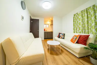 a living room with a white couch and a table at \u845b\u98fe\u9ad8\u7802\u6238\u5efa in Tokyo