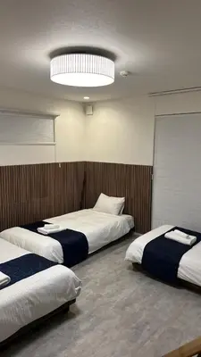 a room with three beds and a large light at \u795e\u5bae\u524d2\u4e01\u76ee in Tokyo