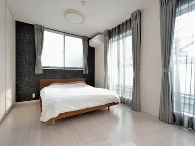 a bedroom with a bed and large windows at \u795e\u5bae\u524d2\u4e01\u76ee in Tokyo