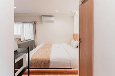 a small bedroom with a bed and a television at Shinjuku SAIEI Hotel in Tokyo