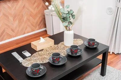 a black coffee table with four cups and a vase at Shinjuku SAIEI Hotel in Tokyo