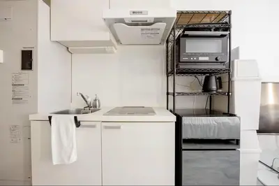 a white kitchen with a sink and a microwave at \u767d\u91d16\u4e01\u76ee401 in Tokyo
