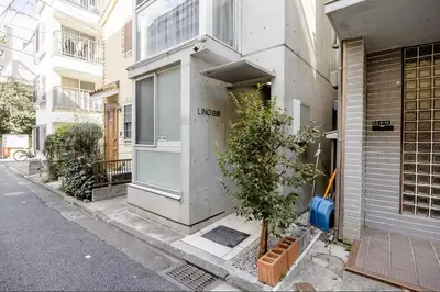 a building with a tree on the side of a street at \u767d\u91d16\u4e01\u76ee401 in Tokyo