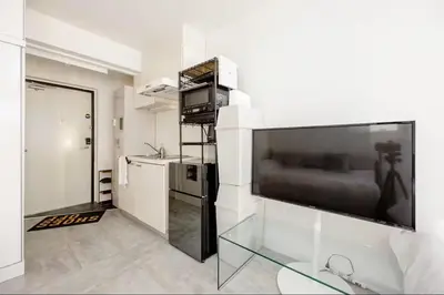 a living room with a large flat screen tv on a wall at \u767d\u91d16\u4e01\u76ee401 in Tokyo