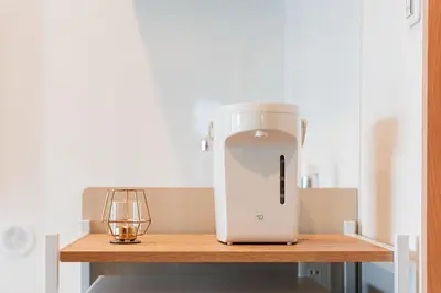 a white mixer sitting on a wooden table with a candle at Shinjuku SAIEI Horizon Hotel in Tokyo