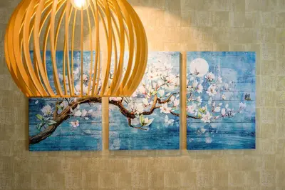 three paintings of a tree with flowers on a wall at Camo's Tokyo Oshiage in Tokyo