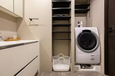 a laundry room with a washer and dryer in it at Camo's Tokyo Oshiage in Tokyo