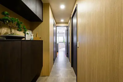 a hallway with wood paneling and a long hallway with a hallway at Camo's Tokyo Oshiage in Tokyo