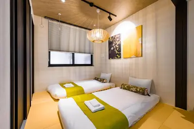 a bedroom with two beds and a chandelier at Camo's Tokyo Oshiage in Tokyo