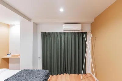 a bedroom with a bed and a green curtain at Shinjuku SAIEI Hotel 201 in Tokyo