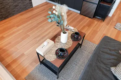 a coffee table with a vase with flowers on it at Shinjuku SAIEI Hotel 201 in Tokyo