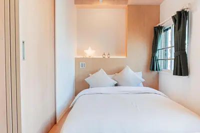 a bedroom with a white bed and a window at Shinjuku SAIEI Hotel 201 in Tokyo