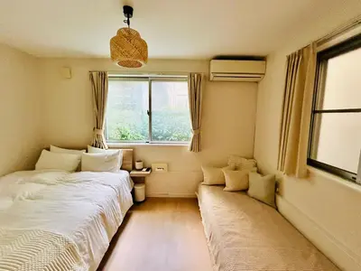 a small bedroom with two beds and a window at \u6674Hare Hotel in Tokyo