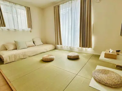 a living room with a couch and two ottomans at \u6674Hare Hotel in Tokyo