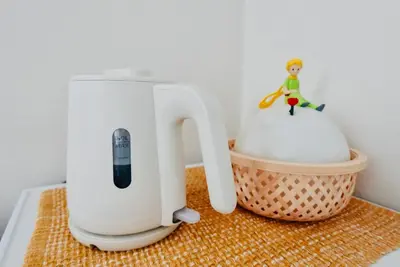 a white blender sitting on a counter next to a basket at \u6674Hare Hotel in Tokyo