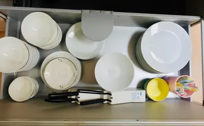 a bunch of white plates and pans in a drawer at \u6674Hare Hotel in Tokyo