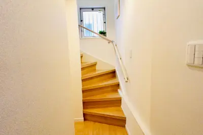 a staircase in a home with wooden floors and white walls at \u6674Hare Hotel in Tokyo