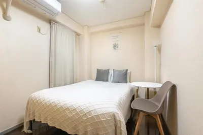 a small bedroom with a bed and a chair at tokyo mirai 3F in Tokyo