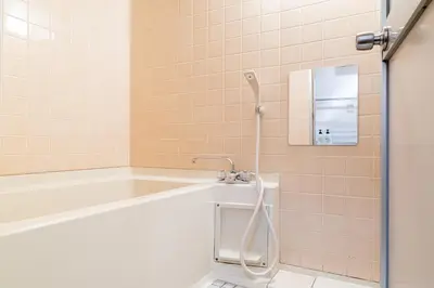 a bathroom with a bath tub and a mirror at tokyo mirai 3F in Tokyo