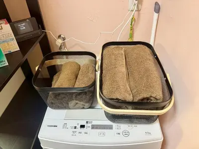 two containers of towels sitting on top of a washing machine at Tokyo Stay Ikebukuro East in Tokyo