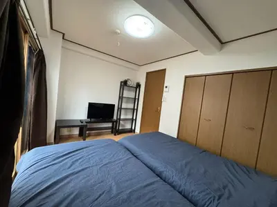 a bedroom with a blue bed and a desk at Tokyo Stay Ikebukuro East in Tokyo