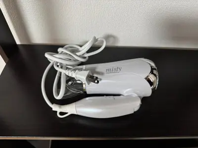 a white hair dryer sitting on a black shelf at Tokyo Stay Ikebukuro East in Tokyo