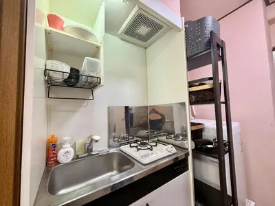 a small kitchen with a sink and a shelf at Tokyo Stay Ikebukuro East in Tokyo