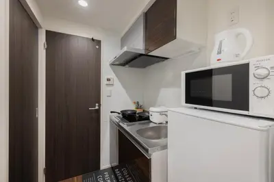 a small kitchen with a sink and a microwave at self-check in HomeNest Akihabara in Tokyo