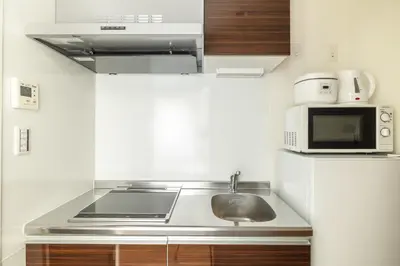 a kitchen with a sink and a microwave at self-check in HomeNest Akihabara in Tokyo