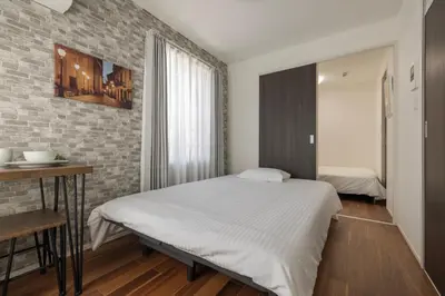 a bedroom with a bed and a brick wall at self-check in HomeNest Akihabara in Tokyo
