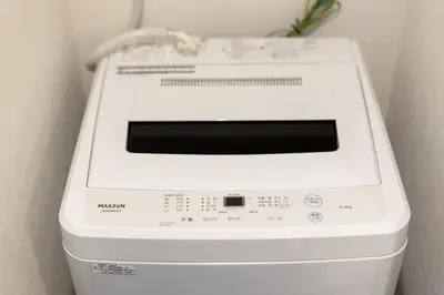 a white washing machine sitting in a room at self-check in HomeNest Akihabara in Tokyo