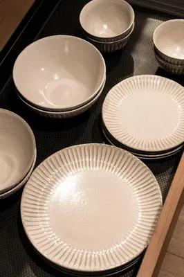 a group of white plates sitting on a table at Cava House in Tokyo