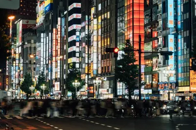 a crowd of people crossing a city street at night at Cava House in Tokyo
