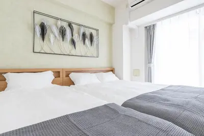 two white beds in a bedroom with a window at Latte Sakura View Oshiage, 10min walk to Tokyo Skytree, walk to Asakusa in Tokyo